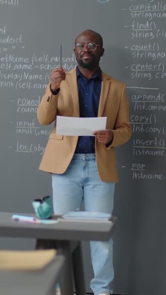 Vertikale Vollaufnahme Eines Afroamerikanischen Lehrers Der Vor Einer Tafel Steht — Stockvideo