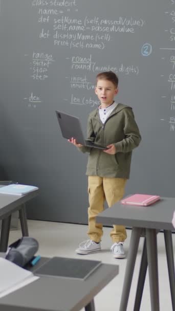 Повний Знімок Хлопчика Початкового Віку Стоїть Перед Класом Тримає Ноутбук — стокове відео