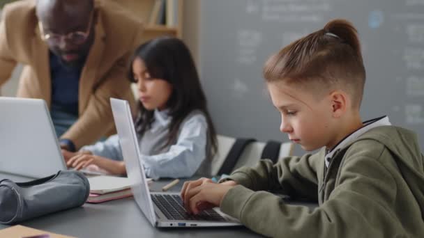 Medium Shot Caucasian Elementary Age Boy Sitting Desk Classroom Typing — Stock Video