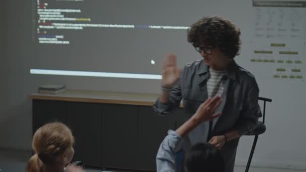 学校の教室でプログラミングレッスン中に高5歳から小学生を授与する陽気な女性教師のスローモフルショット — ストック動画