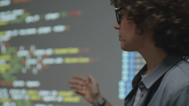 昼間の教室の生徒に新しい教材を説明するコードの例でスクリーン投影を見ている女性のコーカサス教師のクローズアップ — ストック動画