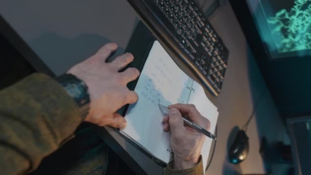 纵观身披军服 无法辨认的男子手 坐在监视中心的办公桌前 一边用复印机书写 一边用计算机键盘打字 — 图库视频影像