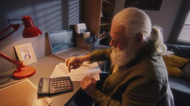 Μέτριο Πλάνο Του Ηλικιωμένου Άνδρα Που Κάθεται Στο Γραφείο Κοιτάζοντας — Αρχείο Βίντεο