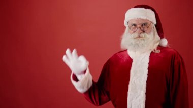 Kırmızı ceketli, gözlüklü ve beyaz eldivenli gülümseyen Noel Baba 'nın yakın plan resmi. Kopyalama alanı, şablon kadar uygun