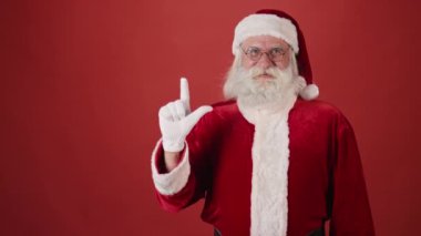 Kırmızı kıyafetli ve beşe kadar sayan yaramaz Noel Baba 'nın orta boy fotoğrafı renkli konfetiyle parti patlayıcısını ateşledikten sonra dans edip boğmaca. Şablon, boşluğu kopyala