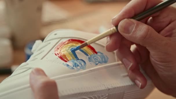 Extremo Close Pessoa Irreconhecível Desenhando Arco Íris Tênis Branco Interior — Vídeo de Stock
