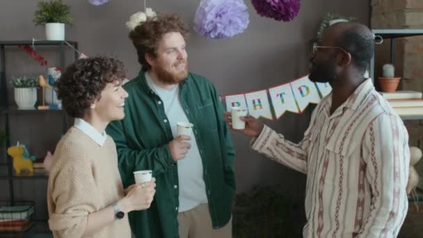 中年白人男女穿着休闲装 卷曲的头发和非洲裔美国男性朋友在生日派对上站在家里聊天 — 图库视频影像