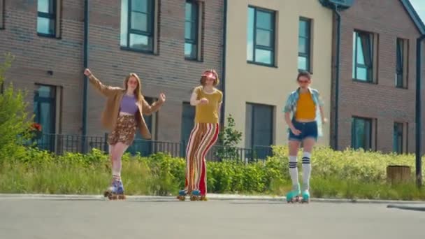 昼間のカメラアウトドアに向かってローラースケートで同期的に3人の陽気な女の子のワイドショット — ストック動画