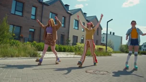 3人の女性ミレニアル世代のスローモフルショットは 昼間の屋外でのローラースケートのトリックを同期的に行います — ストック動画