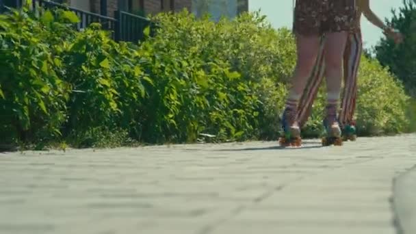 昼間のカメラの屋外に向かってクワッドスケートを行っている2人の認識できない女の子の地上レベルの安定したショット — ストック動画
