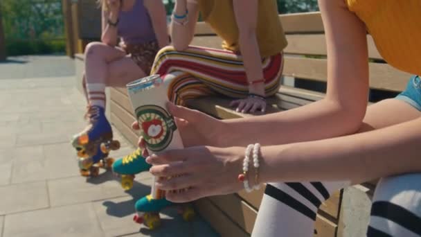 夏日阳光明媚的时候 有选择地把注意力集中在拿着一罐苏打水 与朋友坐在公园长椅上 默默无闻的小女孩的手上 — 图库视频影像