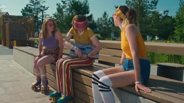 三个快乐的少女 穿着嬉皮士的衣服 打开复古的音乐 白天骑着四足冰鞋出去玩 — 图库视频影像