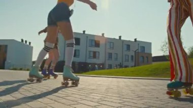 Üç bin yıllık renkli retro giysili Hollandalı kızlar gündüz vakti paten sürerken eğleniyorlar.