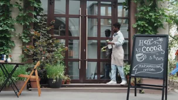 Amplio Plano Camarero Afroamericano Limpiando Limpiando Puerta Cristal Del Restaurante — Vídeo de stock