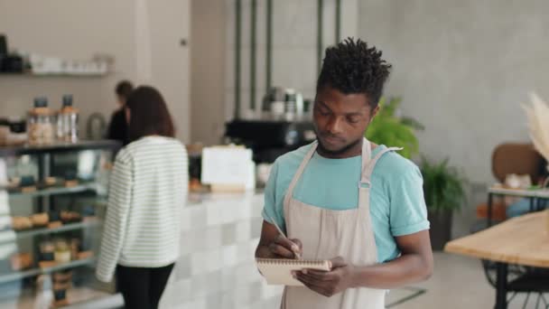 Retrato Médio Amigável Olhando Garçom Afro Americano Café Fazendo Anotações — Vídeo de Stock