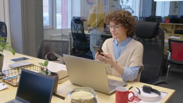 Średni Pełny Strzał Kaukaskiej Kobiety Siedzącej Biurze Smartfonie Pracującej Laptopem — Wideo stockowe