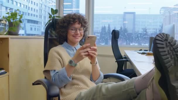 Açık Uzay Ofisinde Bacakları Açık Oturan Ara Veren Akıllı Telefon — Stok video