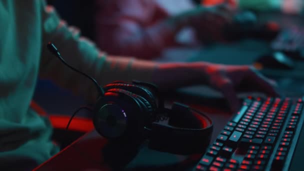 インターネットカフェのコンピュータで椅子に座って ヘッドフォンを置き ビデオゲームをプレイする準備をしている多種多様な若いサイバースポーツチームのクローズアップタイルショット — ストック動画