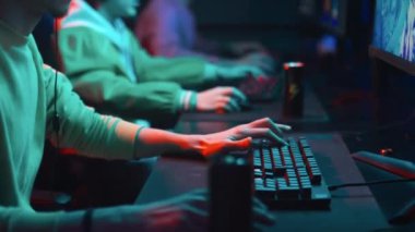 Kulaklıklı, siber kafe 'de oturan video oyunu turnuvasında oynayan, kazanan, alkışlayan ve beşlik çakarak kutlama yapan genç çok ırklı erkek arkadaşlarından oluşan orta ölçekli bir fotoğraf.