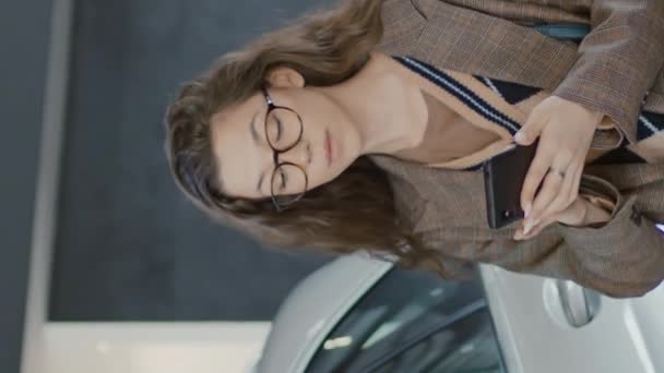 Gözlüklü Beyaz Tenli Genç Bir Kadının Araba Galerisinde Dolaşırken Görüntüdeki — Stok video