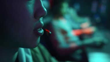 Siber kulüpte birinci şahıs nişancısını oynarken tanınmayan Asyalı bir erkek ya da kızın mikrofona konuştuğu aşırı yakın çekim.