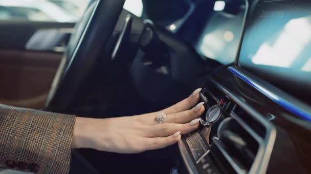 在陈列室里 一个无法辨认的年轻女子摸着新豪华汽车仪表盘 调整通风口的特写镜头 计算机上的西里尔文注册欢迎 — 图库视频影像
