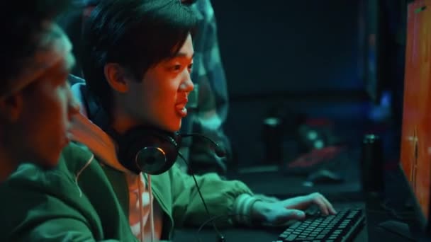 Średnie Zbliżenie Zdjęcia Młodego Chińczyka Siedzącego Cyberkawiarni Grającego Strzelanki Wygrywającego — Wideo stockowe