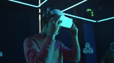 Genç adamın sanal gerçeklik simülasyon oyunundan sonra AR gözlüklerini çıkardığı orta boy bir fotoğraf, erkek arkadaşına sarıldığı, ellerini sıktığı ve gülümsediği.