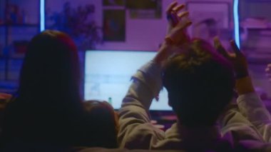 Tanımlanamayan bir grup gencin televizyonun önünde birlikte oturup hokey maçı izledikleri ve alkışladıkları orta boy arka plan fotoğrafları.