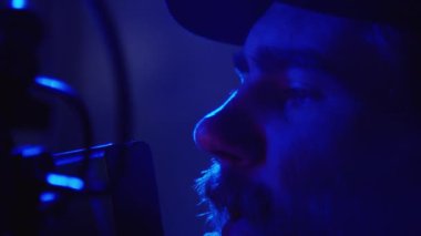 Neon mavi ışık ve dumanla karanlık stüdyoda moda ya da ticari çekimler yaparken profesyonel kameramanların görüş açısına bakıp modellere talimat verirken son derece yakın çekim görüntüleri.