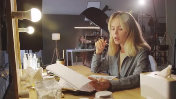 Genç Beyaz Kadın Yapımcının Prodüksiyon Stüdyosunda Oturmuş Senaryo Senaryoya Bakarken — Stok video