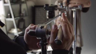 Bilinmeyen bir erkek fotoğrafçının yatay kamera rafının düğmesini sıkarken ve tanınmayan bir asistanla sohbet ederken orta boy çekimleri.