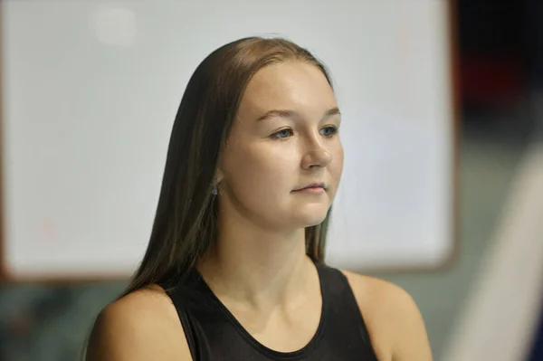 トレーニング後のスタジアムでカメラの前に立っている間 長いまっすぐな髪の若いセレン女性の水泳選手 — ストック写真