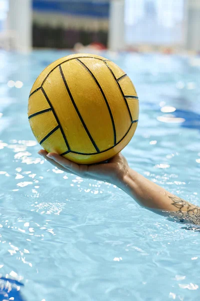 Mano Atleta Joven Sosteniendo Bola Amarilla Durante Juego Waterpolo Mientras —  Fotos de Stock
