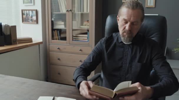 Modern Olgun Kafkas Rahibi Ofisinde Oturmuş Kitap Okuyor Defterine Alıntılar — Stok video