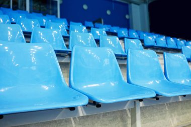 Geniş modern stadyumdaki boş tribünlerin mavi plastik sandalyelerinde çeşitli spor müsabakaları, yarışmalar ve oyunların hayranları için kimse yok.