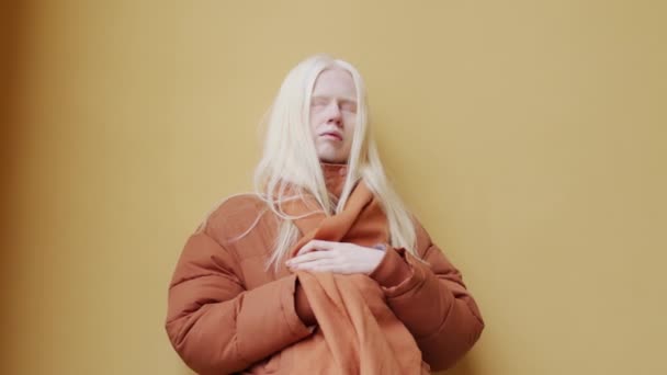 站在室外黄墙背景下的长发年轻白化病妇女的低视角中肖像画 — 图库视频影像