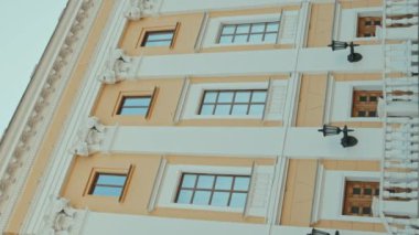 Dikey eğim, üç ahşap kapılı beyaz ve sarı binanın bir kısmının görüntüsünü oluşturur.