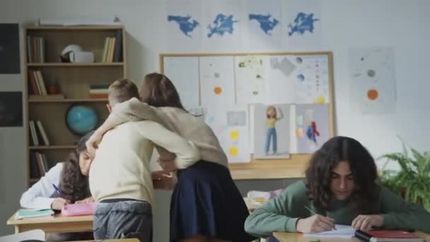 Sınıf Arkadaşları Defterlerine Tutarken Kız Oğlanın Kamerasıyla Birbirlerini Itip Kakışlarını — Stok video