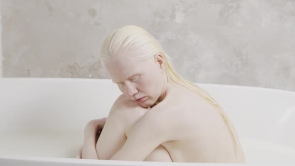 湿头发忧郁的白化病妇女的画像 双目紧闭在浴缸里抱着她的膝盖 — 图库视频影像