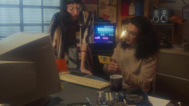 レトロガレージオフィスで働く若い男女がフロッピーディスクにデータを保存 90年代の美学 — ストック動画