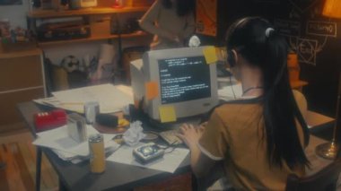 Genç bayan programcı, erkek arkadaşları kağıt savaşı oyunu oynamaya başladığında kod üzerinde çalışıyor.