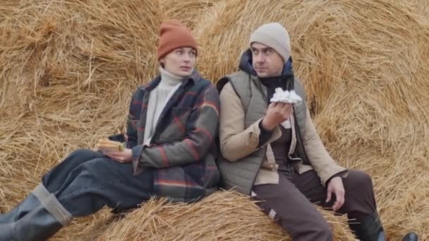 白人男子和妇女在农场一起工作 坐在干草堆上吃饭和说话的画像 — 图库视频影像