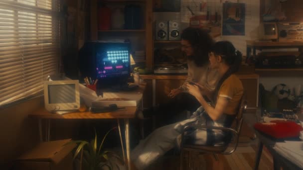 休憩中にコンソールビデオゲームをプレイするレトロガレージオフィスに座っている若い男性と女性の同僚 — ストック動画
