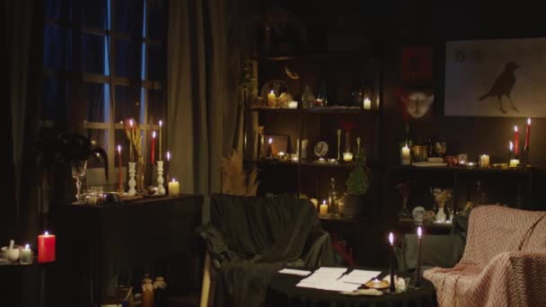 中远景算命师黑暗房间工作室 有大量的蜡烛 海报和与客户合作的地方 — 图库视频影像