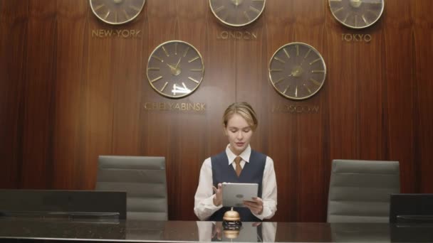 Otel Lobisindeki Saatlerle Arka Planda Dijital Tablet Bilgisayarla Çalışan Kadın — Stok video