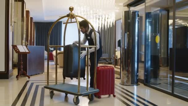 旅馆工作人员把客户的行李放在专用设备上 并运送到房间的长镜头 — 图库视频影像