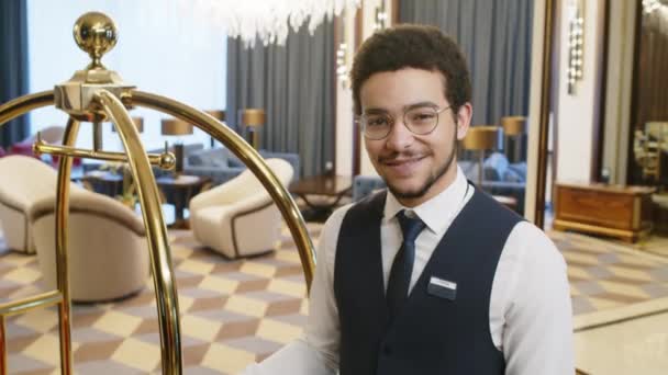 Portræt Hotelarbejder Poserer Kamera Mens Stående Ved Bagage Vogn Hallen – Stock-video