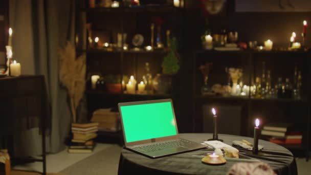 带绿色彩色按键屏幕的手提电脑的中景照片 放在有暗装潢的算命师房中 — 图库视频影像