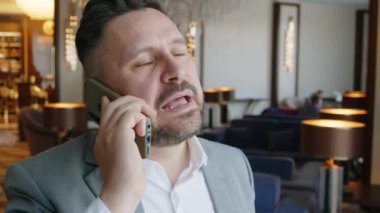 Girişimcinin oteldeki iş yerindeki ortağıyla akıllı telefondan konuştuğu yakın çekim.